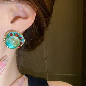 Detailed macro view of vintage geometric round stud earrings with colorful crystal inlay