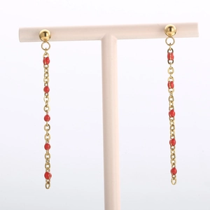 Bohemian gold long tassel drop earrings with red beads on a jewelry display stand