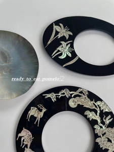 Macro detail of shell inlay patterns including pine, crane, and deer on black lacquer finish