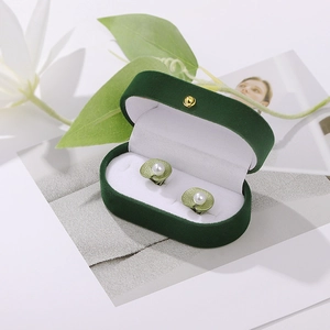 Exquisite pearl green leaf earrings displayed in a luxury dark green velvet jewelry box