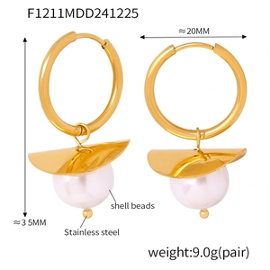 Detail of 35mm golden stainless steel hoop earrings with elegant shell beads and 20mm width