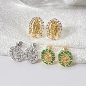 Macro detail of oval 18K gold and silver portrait earrings with green and clear zircon