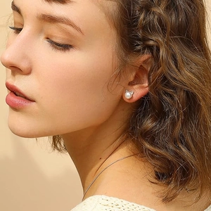 Detailed close-up of a cat ear pearl earring on model with elegant soft lighting
