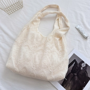 Detail shot of vintage white floral lace tote bag with delicate crochet textures