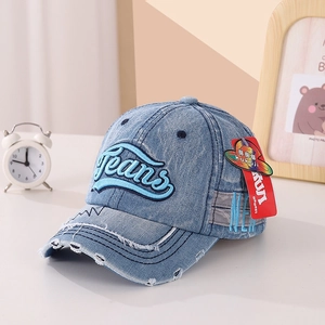 Détail de casquette baseball en jean bleu avec bords usés et broderie Jeans en 3D
