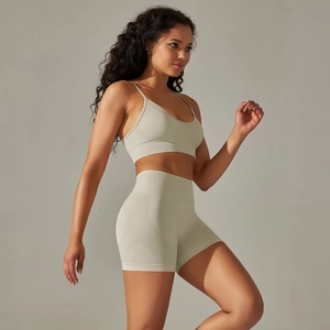 Detail of seamless beige yoga set featuring slim straps and high-waisted fitness shorts