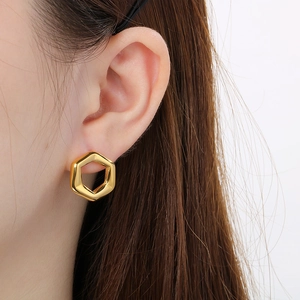 Side view of model wearing a 18K gold-plated hexagonal hollow stud earring in a sleek style