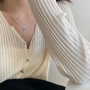 Detail of s925 silver necklace featuring a green rectangular amazonite pendant on model