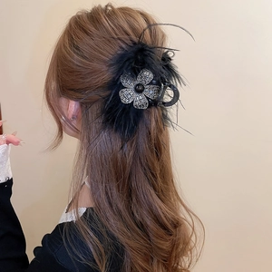 Détail d'une pince à cheveux de luxe avec plumes noires et fleur en strass sur cheveux
