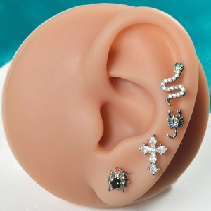 Macro shot of silver stainless steel lip studs in snake, scorpion, and cross shapes