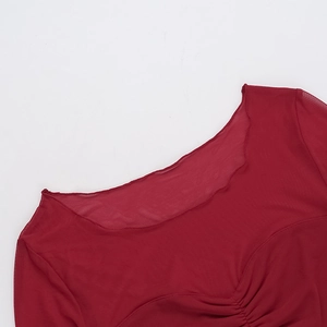 Detailed view of red mesh top featuring elegant ruched bust and sheer fabric texture