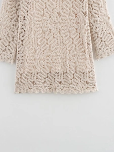 Détail du haut en crochet beige montrant les motifs dentelle et l'ourlet festonné
