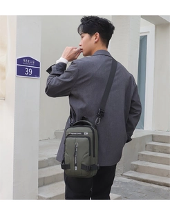 Male model wearing an army green waterproof nylon crossbody chest bag in an urban street setting