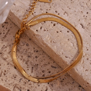 Detailed close-up of 18K gold double-layered snake chain bracelet with polished finish