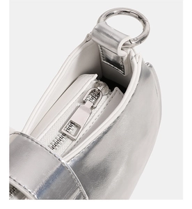 Detail of silver metallic handbag showing the zipper and circular hardware rings