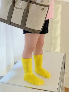 Cotton ribbed mid-calf crew socks for kids in bright yellow featuring a knitted texture