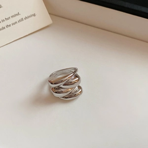 Detailed macro view of a silver-toned layered chunky ring with a polished metallic finish