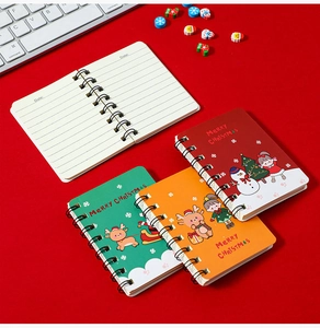 Christmas-themed A7 spiral notebooks with Santa and reindeer motifs on a festive red background