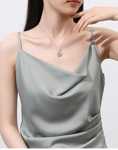 Close-up of a model wearing a S925 silver sunflower pendant with a bright yellow stone