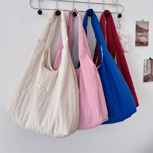 Detailed texture of pleated fabric tote bags in white pink blue and burgundy colors