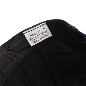 Detail showing the 100% cotton material tag and care instructions for this flat brim cap