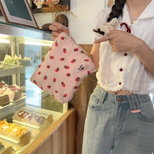Détail du sac cabas rose en velours côtelé avec broderie fraise dans une boulangerie