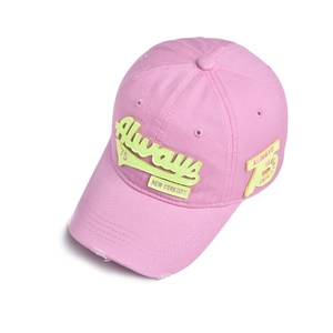 Close-up of distressed pink cotton baseball cap with yellow 3D embroidery and vintage details