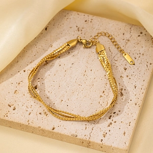 Detalle de pulsera de cadena de serpiente de varias capas dorada con cierre de langosta