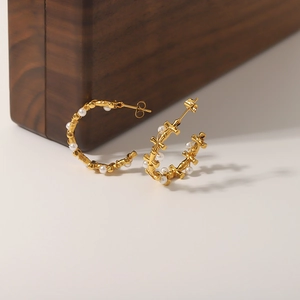 Golden C-shaped stainless steel earrings with inlaid white pearls and cross elements
