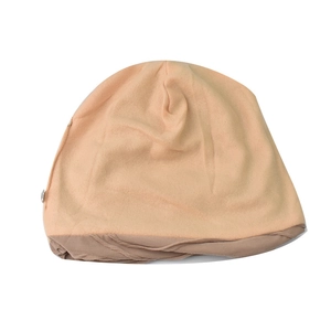 Detail of knitted beige beanie showing two-tone contrast and soft fabric texture