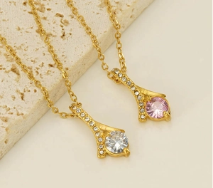 Detail of round white and pink crystal necklaces on beige stone, luxury gold pendants