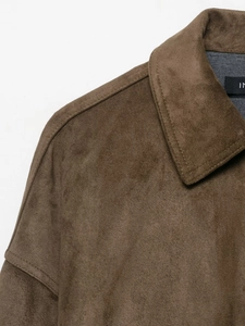 Detailed close-up of dark brown suede jacket collar and fabric texture with sharp focus