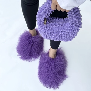 Detail view of purple plush handbag with golden zipper and matching furry slippers set