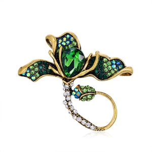 Close-up of vintage flower brooch with emerald green crystals and teardrop center stone
