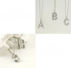 Detailed view of 3D bubble initial pendants A B C H in polished stainless steel finish
