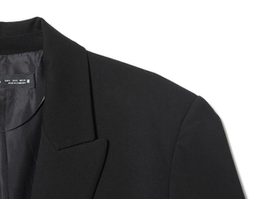 Close-up of padded shoulder and neckline details on a black cropped blazer