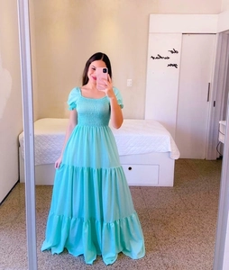 Detail of smocked bodice and tiered skirt on a light blue floral off-shoulder maxi dress