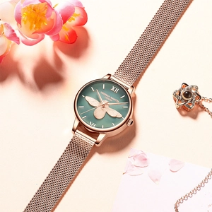 Détail de la montre or rose avec motif abeille 3D et cadran vert sur fleurs