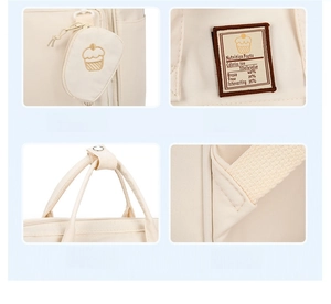Detail view of cream canvas diaper bag featuring cake embroidery and reinforced stitching