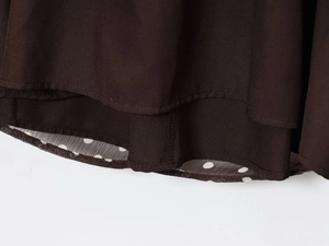 Detailed macro view of brown polka dot fabric hem with neat stitching and double layer