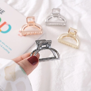 Close-up of minimalist metal hair claw clips in silver, gold, and rose gold finishes