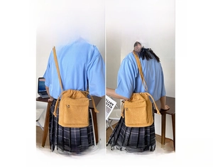 Detailed view of yellow drawstring bucket bag with pleated texture and zipper pocket