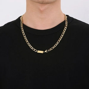 Collier maille Figaro dorée avec pendentif rectangulaire porté sur un t-shirt noir