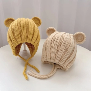 Detailed knit texture of baby winter hats with cute bear ears and protective wind straps