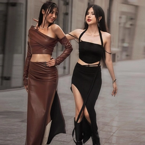 Dettaglio di completi due pezzi con gonna in ecopelle con spacco e top corto alla moda