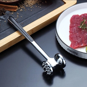 Dual-sided zinc alloy meat tenderizer with ergonomic black grip handle on wooden board