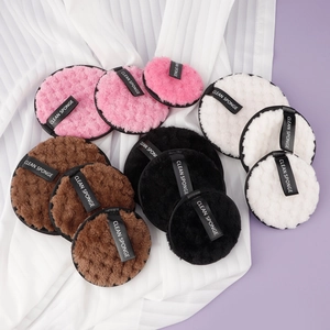Set of four round plush makeup remover sponges in pink, brown, black and white