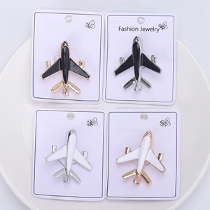 Detailed set of four enamel airplane brooches in gold and silver finishes on display