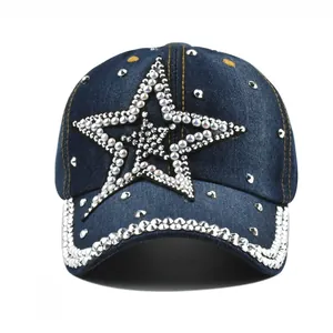 Detail shot of sparkling rhinestone star and brim on washed denim baseball cap