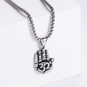 Detailed macro view of silver palm pendant with Om symbol on polished stainless steel